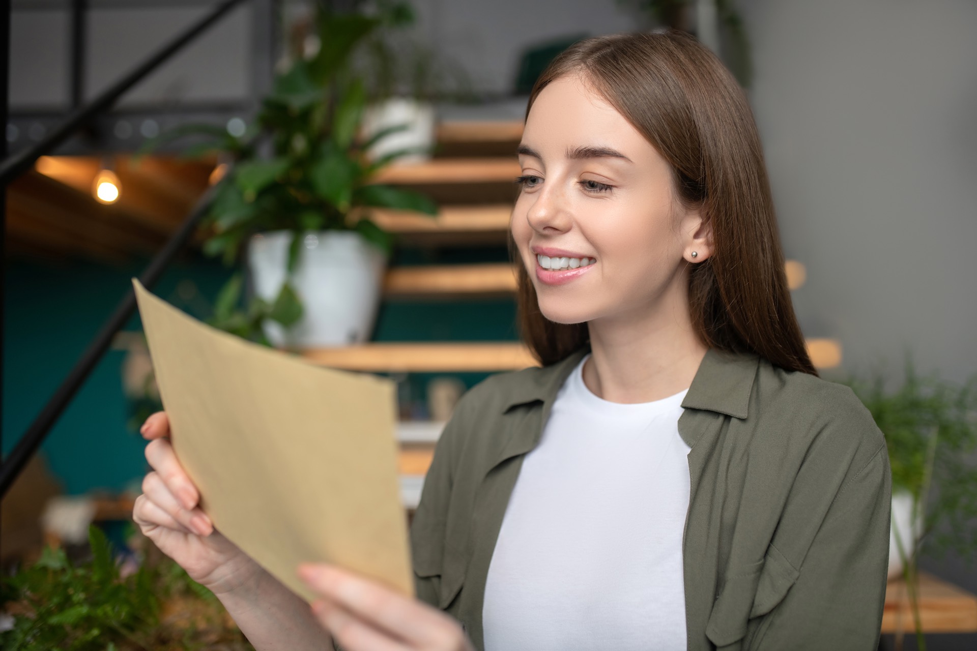 smiling-woman-attentively-reading-a-paper-mail-2021-09-04-07-06-57-utc